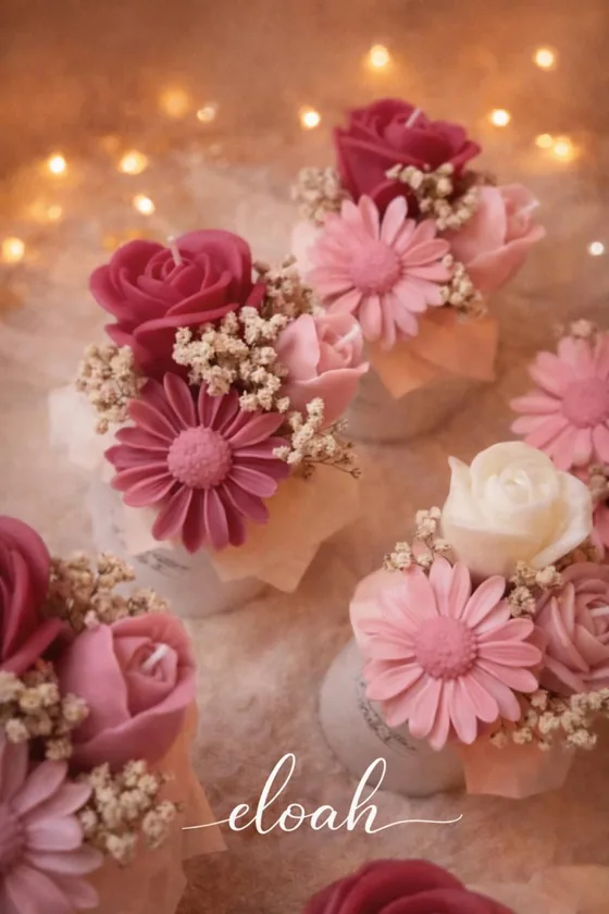 Composición de velas con forma de flores en varios rosados